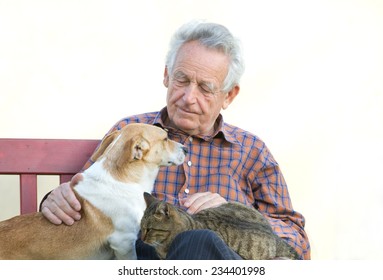 Senior Man With Dog And Cat On His Lap On Bench