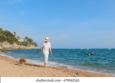 Senior man with dog in white suit walking at the beach  - Powered by Shutterstock