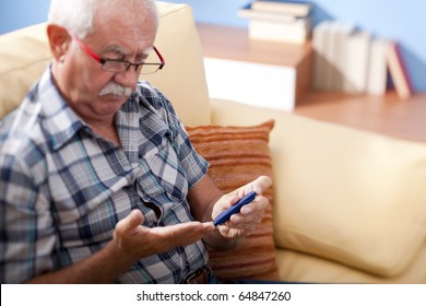 Senior Man Doing Blood Sugar Test At Home