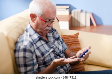 Senior Man Doing Blood Sugar Test At Home