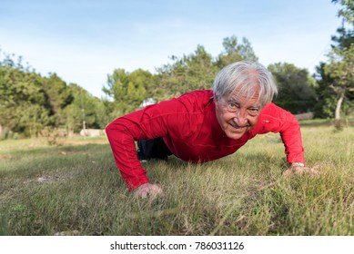 Senior man doing exercise. Push ups. Smiling.