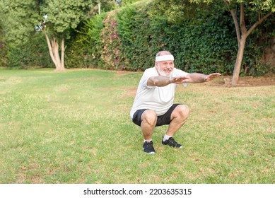 Senior Man Doing Morning Squats In Park