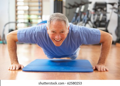 Senior Man Doing Press Ups In Gym