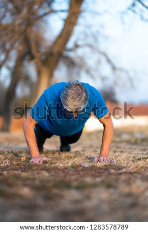 Senior Man doing pushups on an outdoor workout