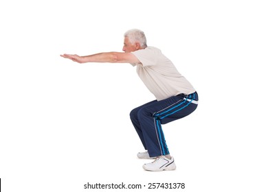 Senior Man Doing A Squat On White Background