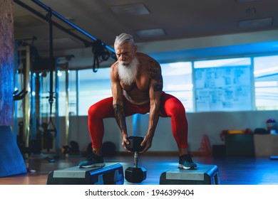 Senior man doing workout exercises inside gym - Fit mature male training in wellness club center - Body building and sport healthy lifestyle concept