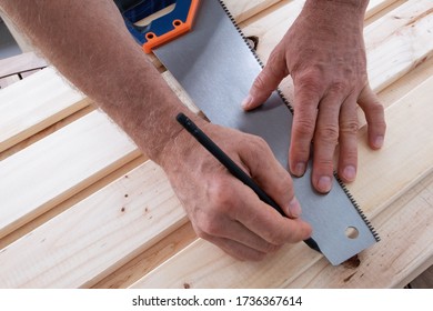 Senior man drawing line and pencil   holding raw as ruler  Handyman restoring wooden shelves at balcony  House improving  DIY   home decoration during quarantine concept