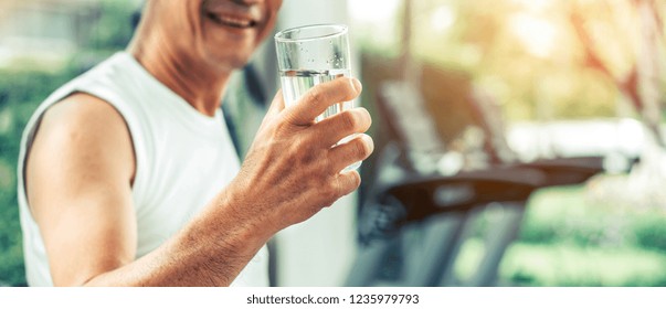 Senior man drink mineral water in gym fitness center after exercise. Elderly healthy lifestyle. - Powered by Shutterstock