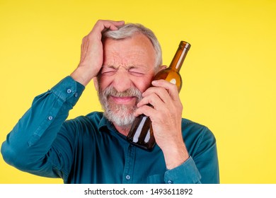 Senior Man Drinking Alcohol Alone Studio Yellow Baclground.