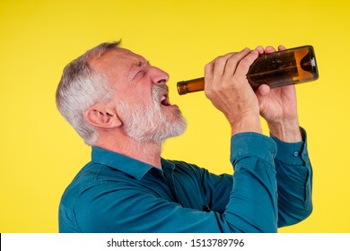 Senior Man Drinking Alcohol Alone Studio Yellow Baclground.