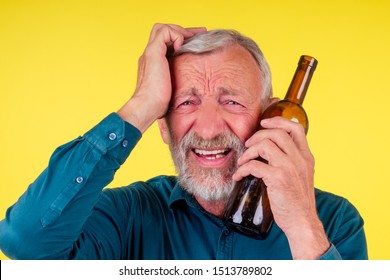 Senior Man Drinking Alcohol Alone Studio Yellow Baclground.