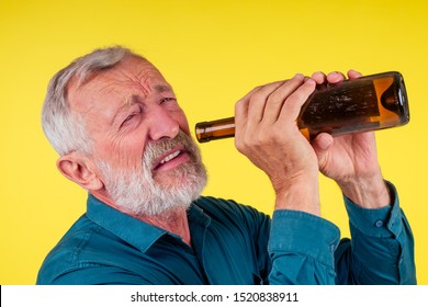 Senior Man Drinking Alcohol Alone Studio Yellow Baclground.