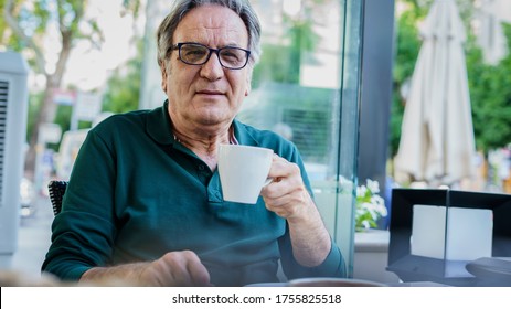 Senior Man Drinking Coffee In Cafe