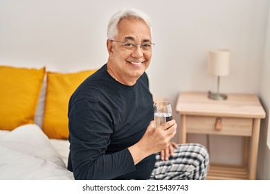 Senior Man Drinking Glass Of Water At Bedroom