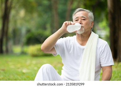 senior man drinking water after workout or exercising in the park - Powered by Shutterstock