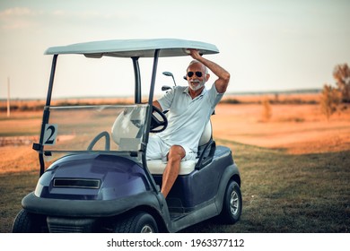 Senior Man Driving Golf Car. 