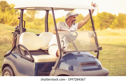 Senior Man Driving Golf Car. 