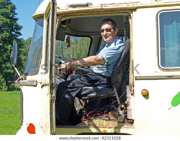 Senior man driving\
old vintage russian bus