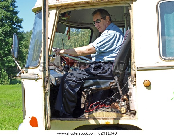 Senior man driving\
old vintage russian bus