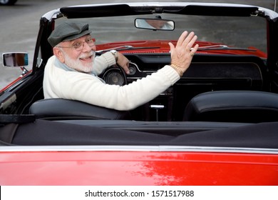 A Senior Man Driving A Sports Car