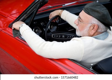 A Senior Man Driving A Sports Car