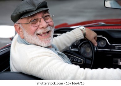 A Senior Man Driving A Sports Car