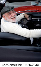 A Senior Man Driving A Sports Car