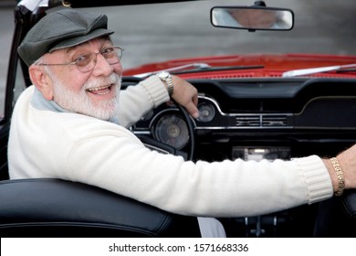 A Senior Man Driving A Sports Car