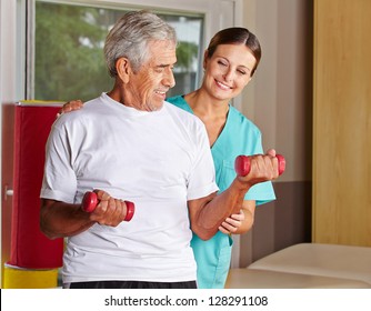 Senior Man With Dumbbells In Rehab With A Physiotherapist