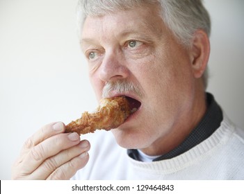 Senior Man Eating Fried Chicken Leg