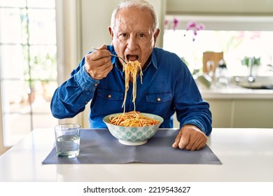 Senior Man Eating Spaghetti At Kitchen