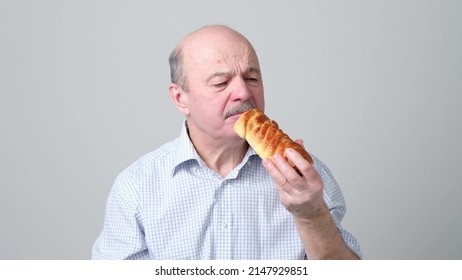 Senior Man Eating Sweet Cakes With Angry Face. He Does Not Like Taste.