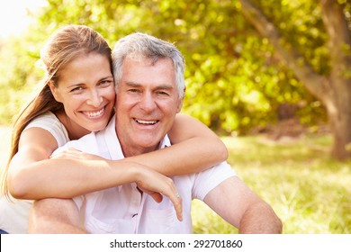 Senior man embraced by his adult daughter, outdoors