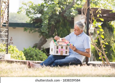 Senior Man Enjoy The Painting At Garden In The Backyard Of The House