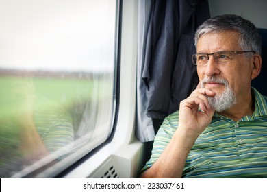 Senior Man Enjoying A Train Travel - Leaving His Car At Home, He Savours The Time Spent Travelling, Looks Out Of The Window, Has Time To Admire The Landscape Passing By