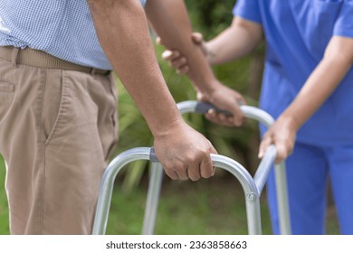 Senior man exercise walking in backyard with caregiver.