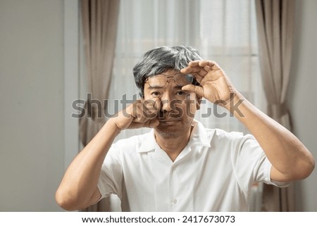 Senior man eye strain after for long stretches at computer or digital screens.