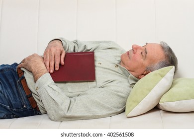 Senior Man Fell Asleep While Reading A Book.Senior Man Napping With A  Book