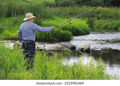 Senior Man Fishing by River in Summer: Leisure, Nature, Outdoors, Retirement, Relaxation - Powered by Shutterstock