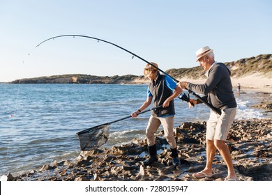 Senior Man Fishing With His Grandson