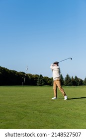 Senior Man In Flat Cap Playing Golf