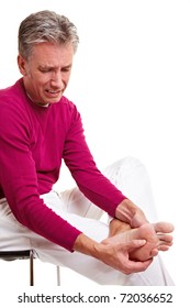 Senior Man With Foot Pain Massaging His Feet