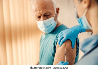 A senior man getting covid 19 vaccine in hospital. Vaccination, inoculation and health care. - Powered by Shutterstock