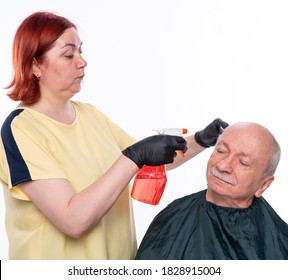 Senior Man Getting A Haircut Over White Background. Woman Wetting  Hair Before Cutting 