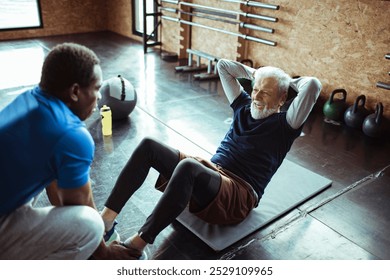 Senior man getting help from trainer during workout at gym - Powered by Shutterstock