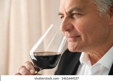 Senior Man With Glass Of Wine Indoors