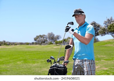 Senior, man and golf club on green grass, field or lawn for sports, choice or selection on course. Mature male person, golfer or player thinking, picking or choosing for score or point in nature - Powered by Shutterstock