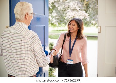 Senior Man Greeting Young Woman Making Home Visit