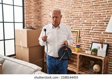 Senior Man With Grey Hair Holding Extension Plug Depressed And Worry For Distress, Crying Angry And Afraid. Sad Expression. 