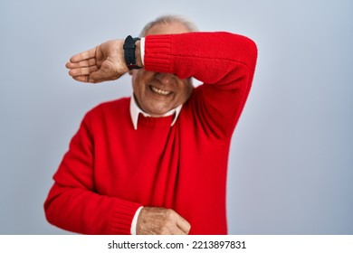 Senior Man With Grey Hair Standing Over Isolated Background Covering Eyes With Arm Smiling Cheerful And Funny. Blind Concept. 